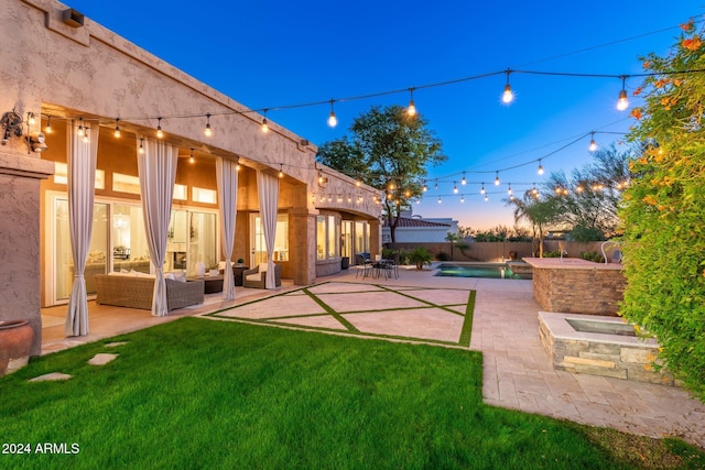 yard at dusk featuring outdoor lounge area, a patio area, and a pool with hot tub