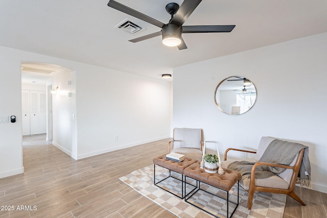 living area featuring light wood-style floors, baseboards, and visible vents