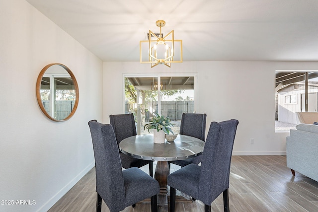 dining area with a notable chandelier, baseboards, and wood finished floors