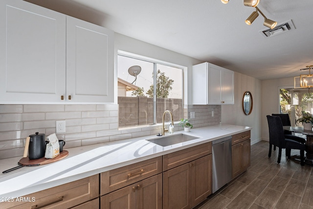 kitchen featuring a sink, white cabinetry, visible vents, decorative backsplash, and dishwasher