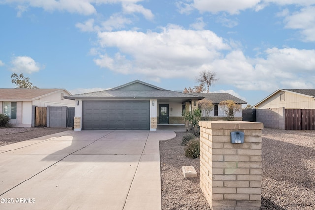 ranch-style house featuring a garage, fence, and concrete driveway