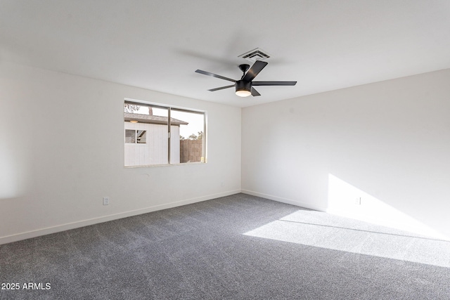 carpeted spare room with visible vents, baseboards, and a ceiling fan