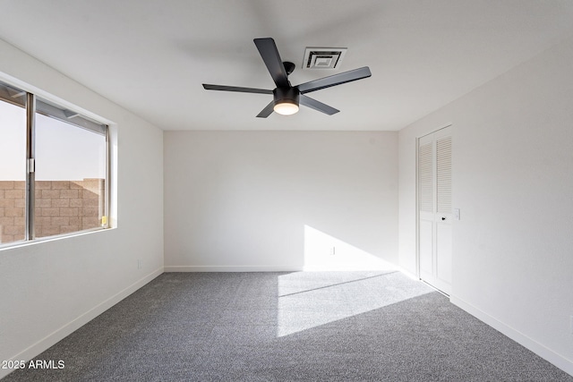 empty room with a ceiling fan, carpet, visible vents, and baseboards