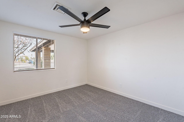 spare room with ceiling fan, dark carpet, visible vents, and baseboards