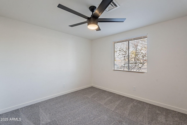 spare room with baseboards, visible vents, dark carpet, and a ceiling fan