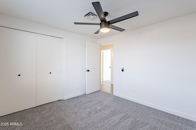 unfurnished bedroom featuring baseboards, visible vents, a ceiling fan, carpet flooring, and a closet