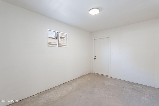 spare room with unfinished concrete flooring