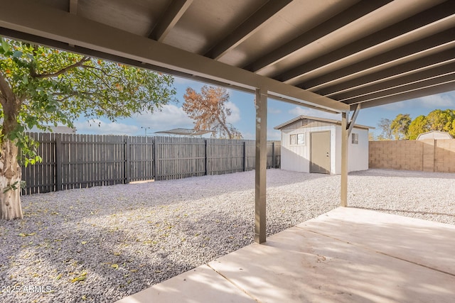 view of yard with a fenced backyard, a patio, an outdoor structure, and a storage shed