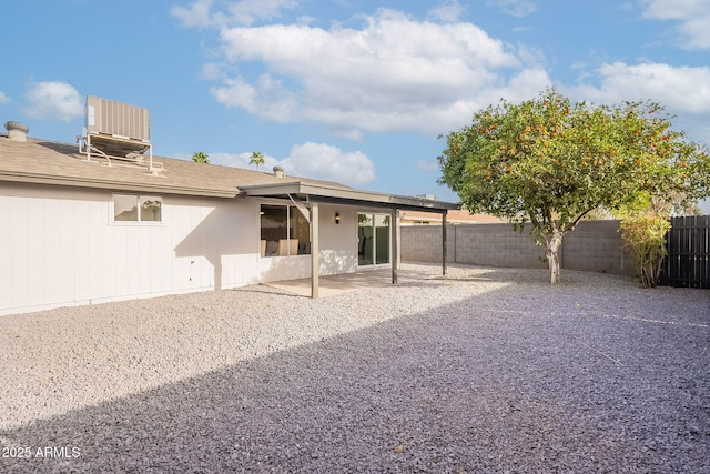 rear view of house featuring a patio area, a fenced backyard, and central air condition unit