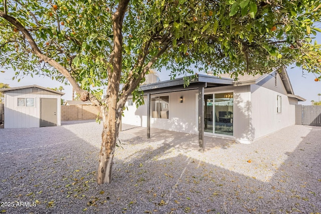 back of property with a patio area, a fenced backyard, a shed, and an outdoor structure