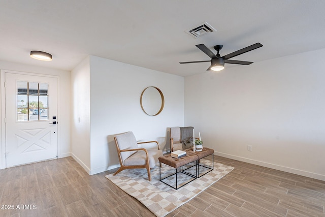 sitting room featuring wood tiled floor, visible vents, and baseboards