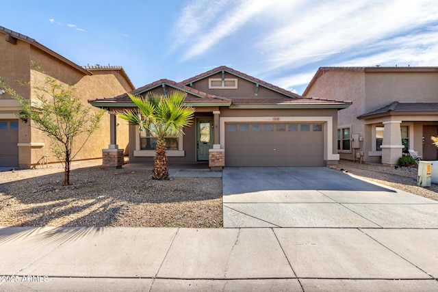 view of front of property featuring an attached garage, a tile roof, concrete driveway, and stucco siding