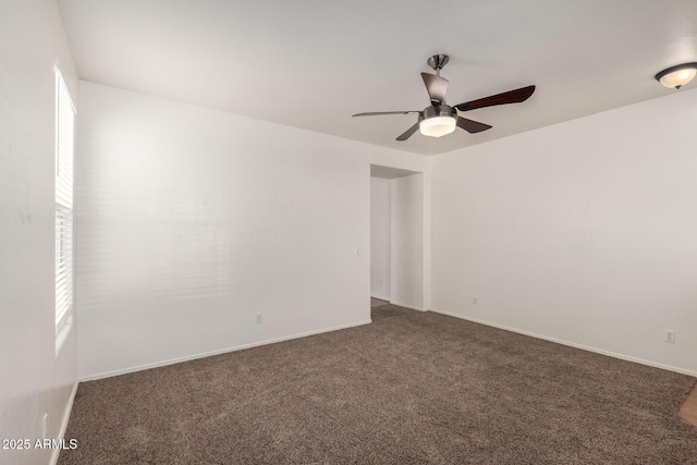 unfurnished room featuring dark carpet, baseboards, and ceiling fan