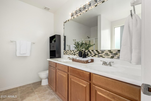 bathroom featuring tasteful backsplash, visible vents, a sink, and an enclosed shower