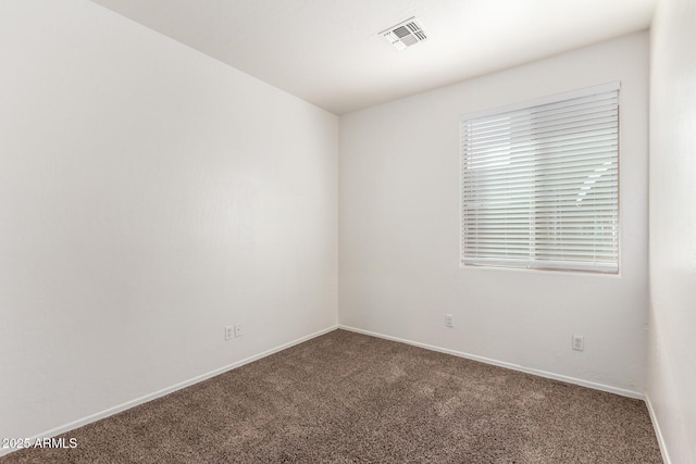 carpeted empty room featuring visible vents and baseboards