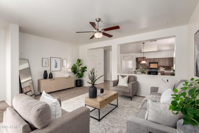 living area featuring ceiling fan and light colored carpet