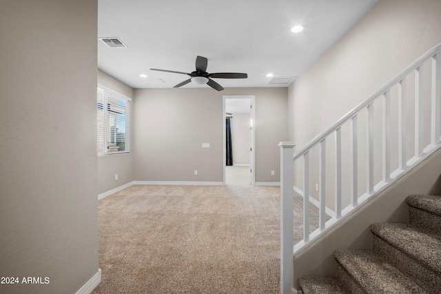 staircase featuring carpet and ceiling fan