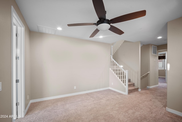 empty room featuring ceiling fan and light carpet