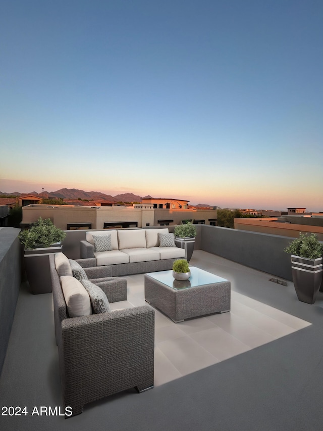 patio terrace at dusk featuring an outdoor hangout area and a mountain view