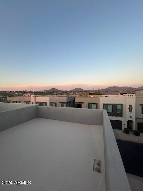 patio terrace at dusk featuring a mountain view and a balcony