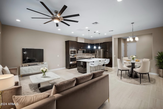 living room featuring ceiling fan and sink