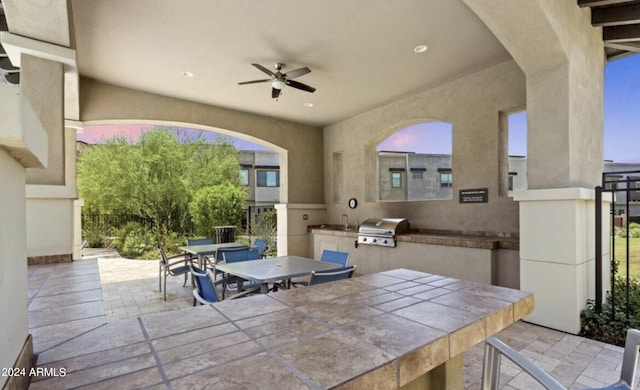 view of patio / terrace with an outdoor kitchen, sink, ceiling fan, and a grill