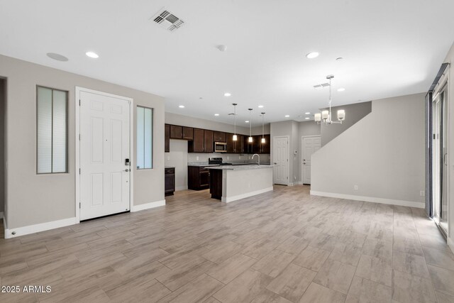 8313 E Impala Ave, Mesa, AZ 85209 - unfurnished living room featuring a chandelier, recessed lighting, light wood-style flooring, and baseboards