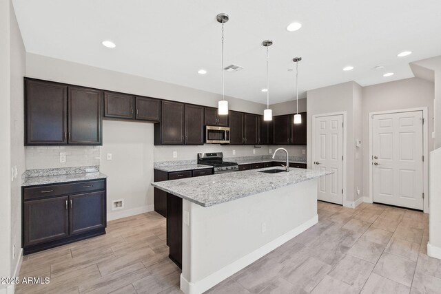 8313 E Impala Ave, Mesa, AZ 85209 - kitchen featuring appliances with stainless steel finishes, a sink, baseboards, dark brown cabinets, and light stone counters