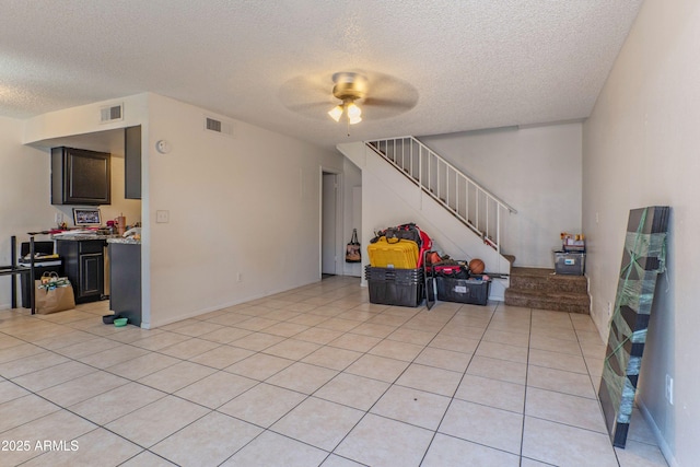 860 E Brown Rd Unit 25, Mesa, AZ 85203 - living area featuring a textured ceiling, a ceiling fan, stairway, and light tile patterned floors