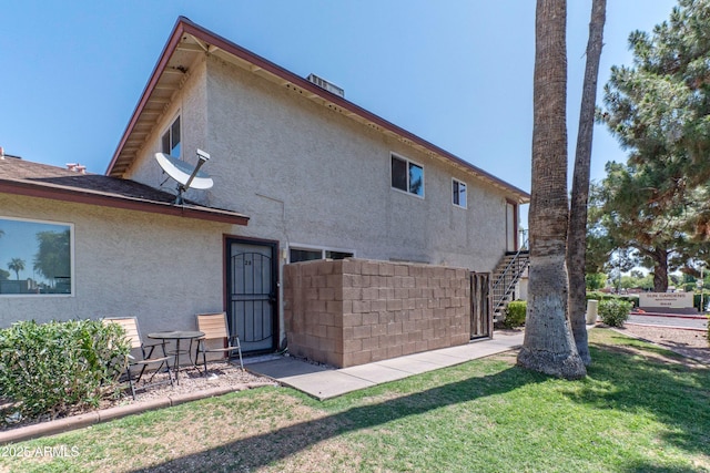 860 E Brown Rd Unit 25, Mesa, AZ 85203 - back of property with stucco siding, stairs, and a lawn