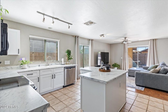 kitchen featuring dishwasher, sink, a center island, and white cabinets