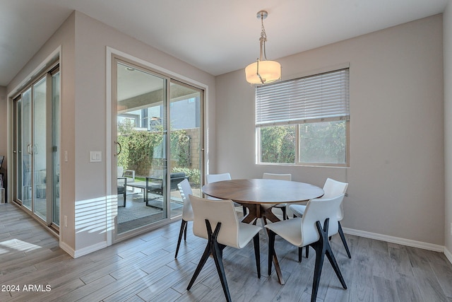 dining area with a wealth of natural light and light wood-type flooring