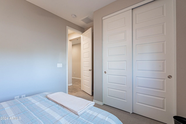 unfurnished bedroom with a closet and light colored carpet