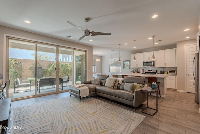 living room with ceiling fan and light wood-type flooring