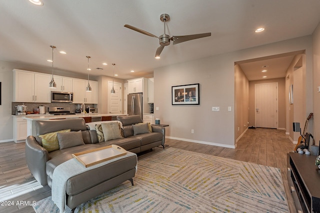 living room featuring light wood-type flooring and ceiling fan