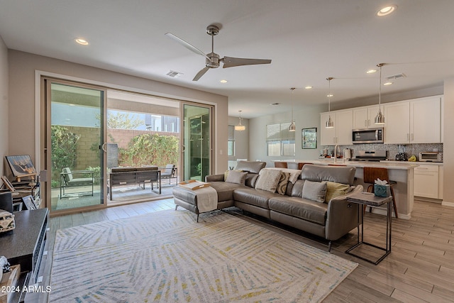 living room featuring light wood-type flooring and ceiling fan