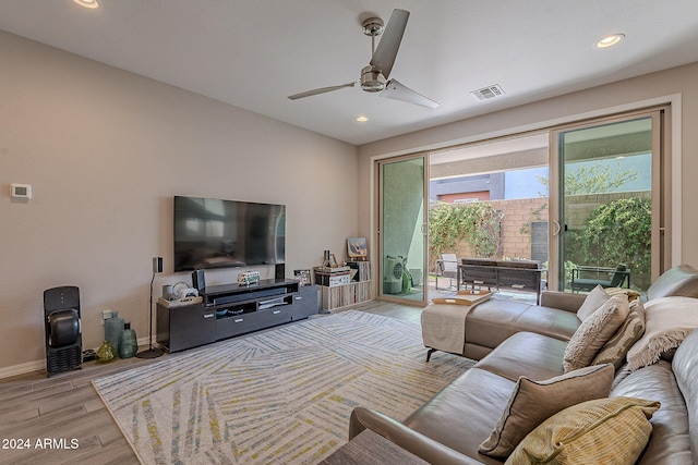 living room with light hardwood / wood-style floors and ceiling fan