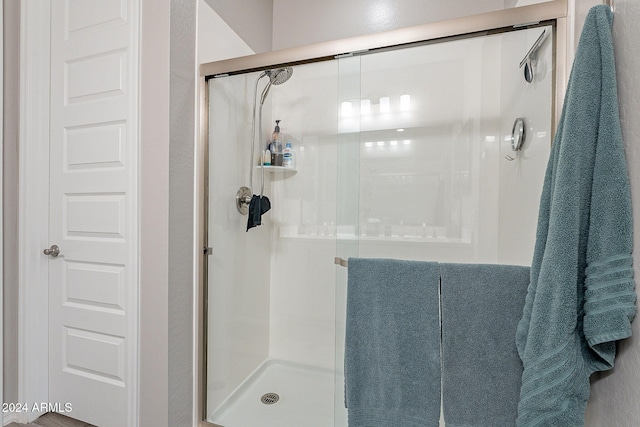 bathroom featuring a shower with door