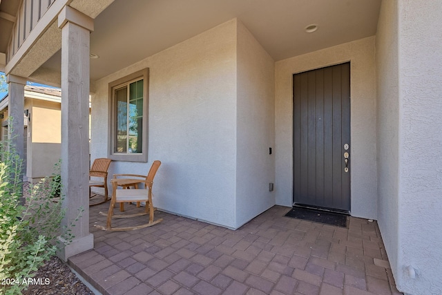 view of exterior entry with a patio area