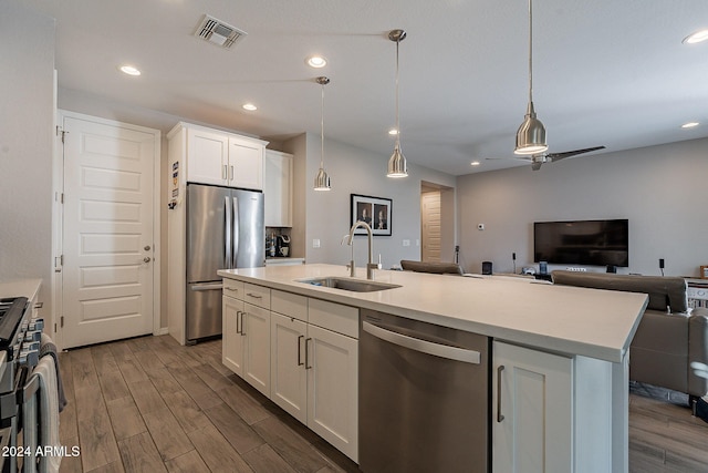 kitchen with sink, an island with sink, stainless steel appliances, white cabinets, and dark hardwood / wood-style floors