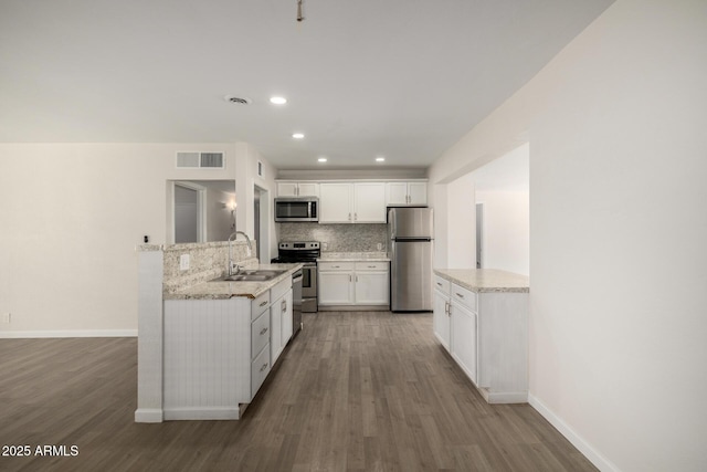 1628 E Sunland Ave, Phoenix, AZ 85040 - kitchen featuring stainless steel appliances, a sink, backsplash, wood finished floors, and recessed lighting