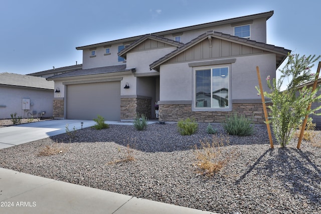 view of front of house with an attached garage, stone siding, board and batten siding, and concrete driveway