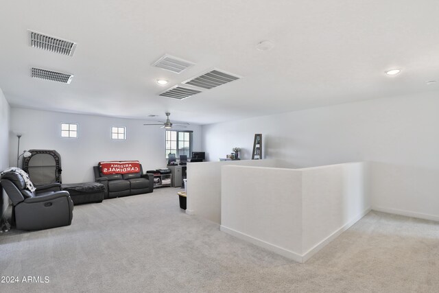 carpeted living room with a ceiling fan, visible vents, and baseboards