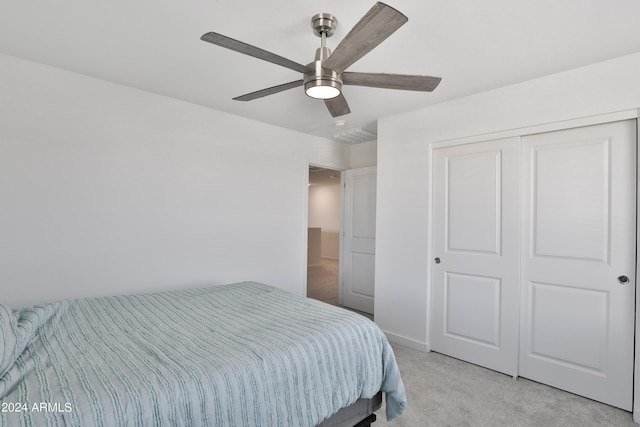 bedroom with a closet, a ceiling fan, and light colored carpet