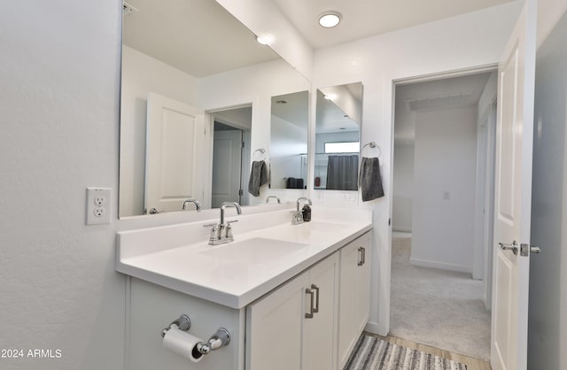 bathroom with double vanity, baseboards, and a sink