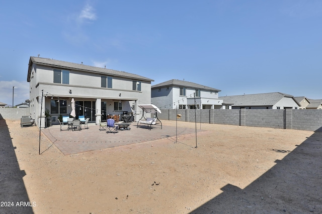 back of house with a patio area, a fenced backyard, and stucco siding