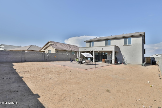 rear view of property with a patio area, a fenced backyard, and stucco siding