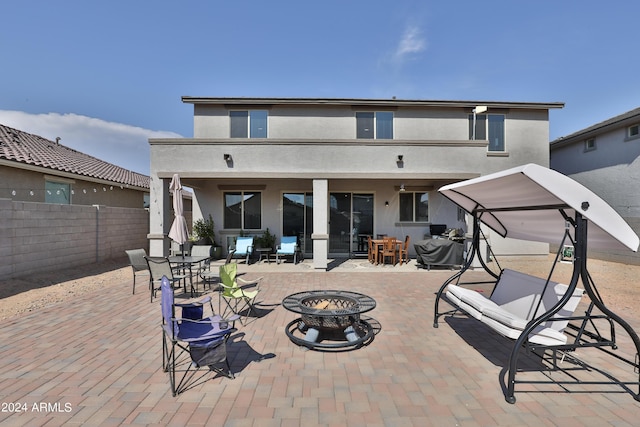 back of house featuring a patio area, fence, a fire pit, and stucco siding