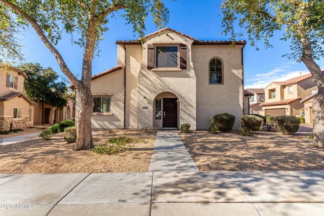 mediterranean / spanish-style home with a tiled roof and stucco siding