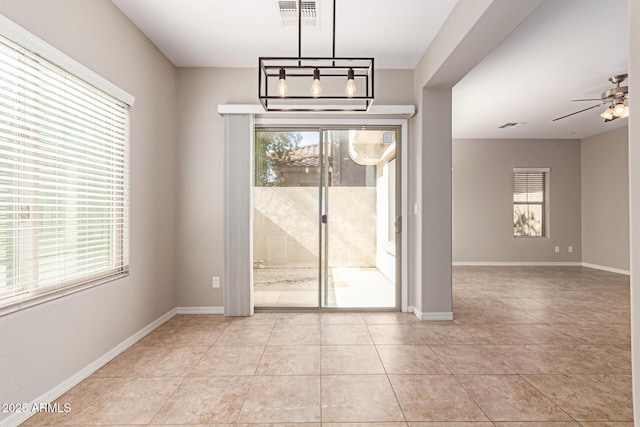 unfurnished dining area with visible vents, plenty of natural light, baseboards, and ceiling fan